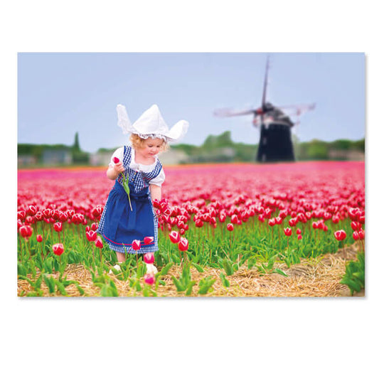Postkaart meisje in klederdracht bij Tulpenveld en molen